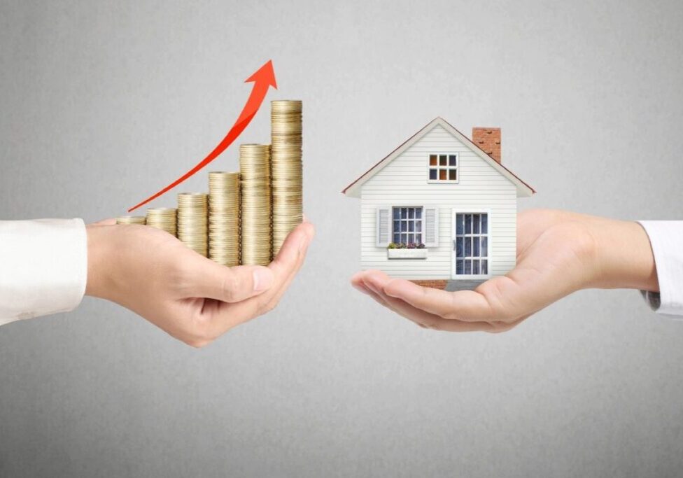 A couple of hands holding up coins and a house.